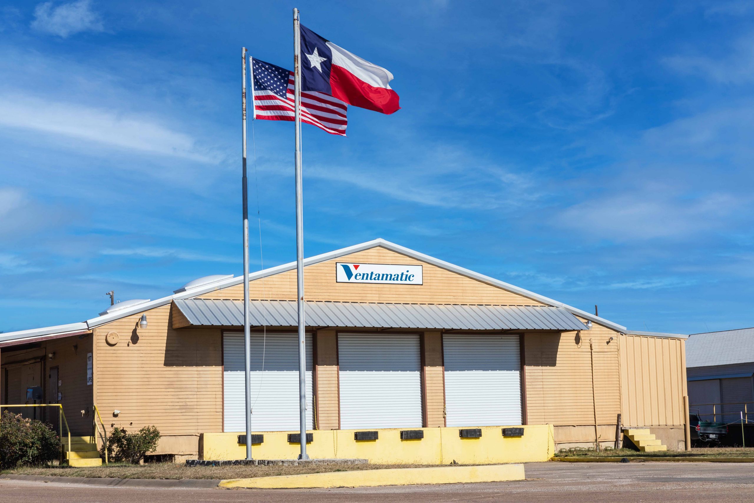 Ventamatic's shipping warehouse with US and Texas flags flying outside.